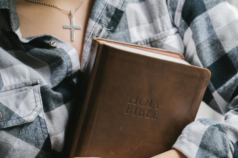 Woman holding a brown leather bible.