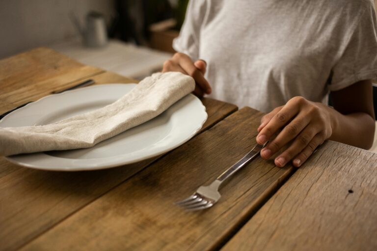 Woman sitting in front of an empty plate.