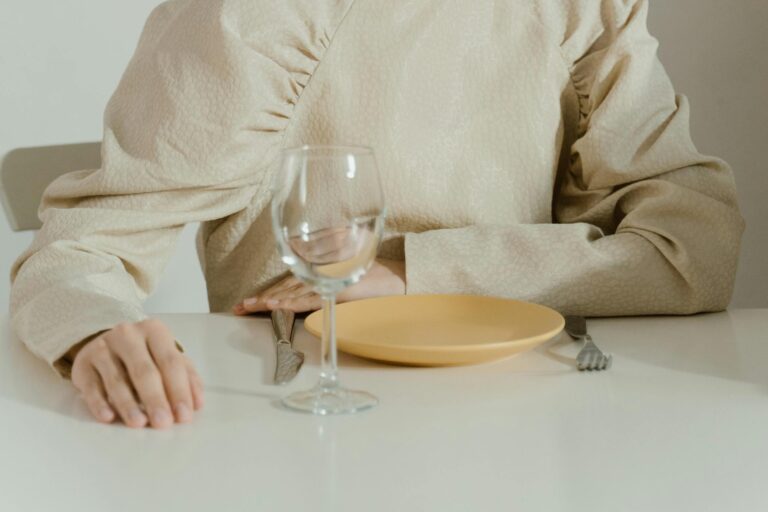 Woman sitting in front of an empty plate and an empty glass