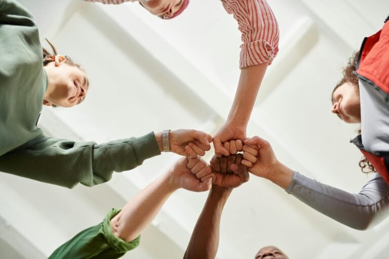 A group of people fist-bumping